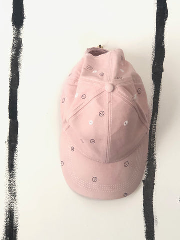 hand dyed pink cap with sad faces drawn on